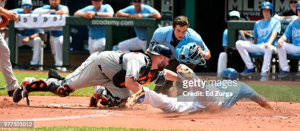 Mike Moustakas of the Kansas City Royals is tagged out by Brian McCann of the Houston Astros as home plate umpire John Tumpane waits to make the call...