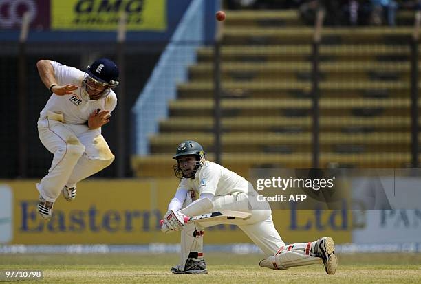 Bangladeshi cricketer Mushfiqur Rahim plays a shot as the England cricketer Ian Bell jumps during the third day of the first Test match between...