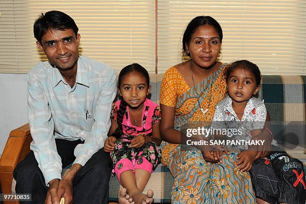 Indian surrogate mother Meenaben Parmar poses with her husband Mineshbhai ) and two children Aakash and Aarti at Kaival Hospital in Anand, some 90...