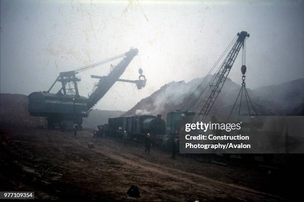 Loading iron ore into wagons to be conveyed to Corby Steelworks, Northamptonshire.