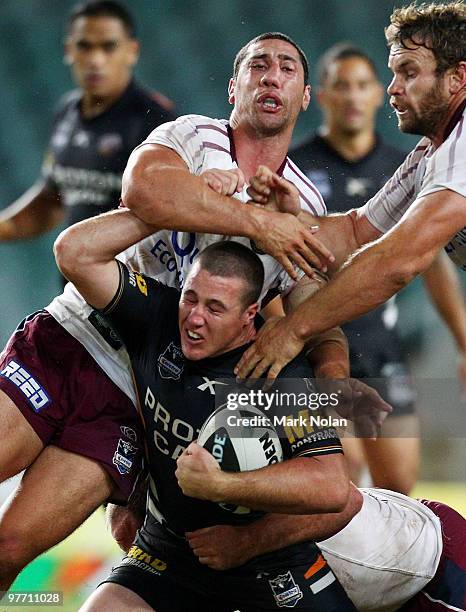 Bryce Gibbs of the Tigers is tackled high by Brent Kite of the Eagles during the round one NRL match between the Wests Tigers and the Manly Warringah...