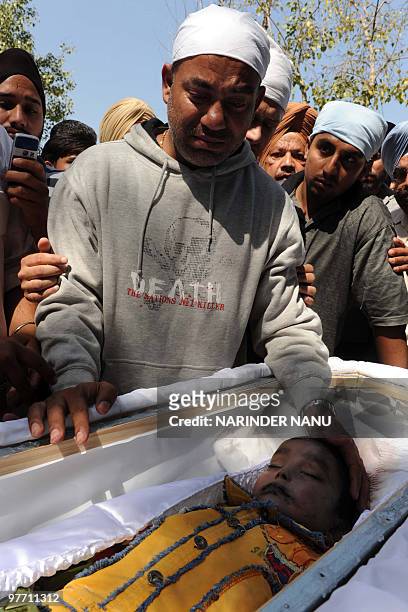 Harjit Singh Channa, father of Indian boy Gurshan Singh who was found dead near a roadside in Melbourne, Australia, mourns by his son's open casket...