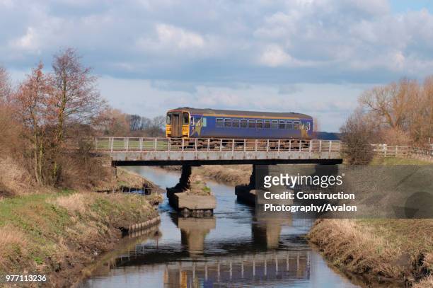 Class 153 Sprinter DMU trainset crosses the river at the approach to Rufford whilst working the Preston - Ormskirk shuttle service. March 2005.
