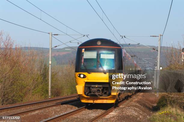 Class 333 EMU trainset races through the Aire Valley with a Leeds - Skipton local service. April 2005.