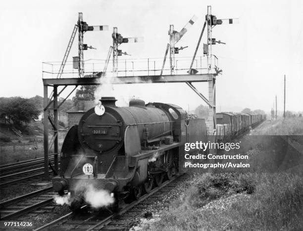 Southern Railways S15 Class 4-6-0 heads past Worting Junction near Basingstoke with a long mixed freight in 1964.