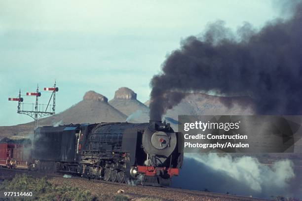 South African Railways condenser 4-8-4 Class 25 at Three Sisters in the Karroo Desert. June 1973.