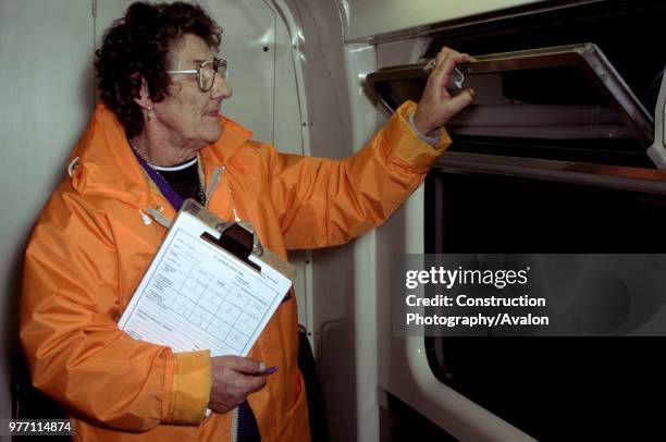 An inspector checks the opoeration of a window during overnight servicing, circa 1993, United Kingdom.
