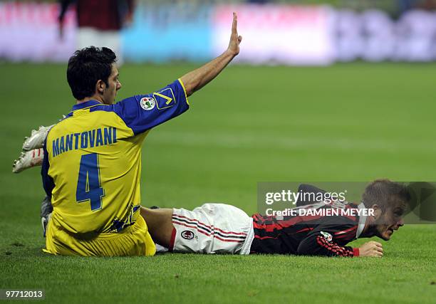 Milan's English midfielder David Beckham lays on the pitch next to Chievo's defender Andrea Mantovani during their Italian Serie A football match on...