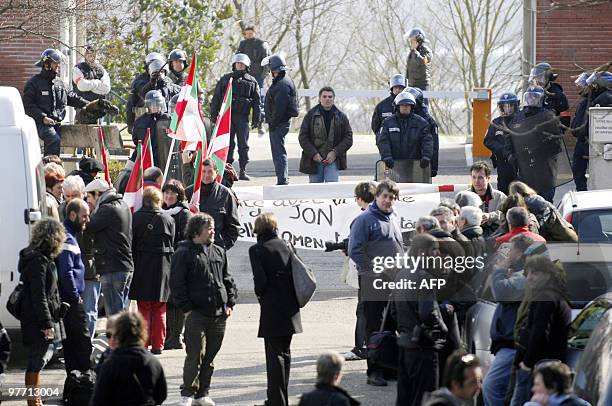 Members of the Jon Anza Committee, a member of the armed Basque separatist group ETA who disappeared nearly a year ago, face police officers during a...