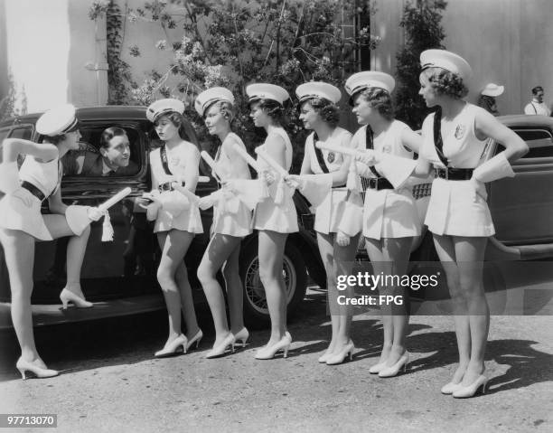 American actor John Boles with extras from his latest musical, 'Redheads On Parade', directed by Norman Z. McLeod, at the Fox Film Corporation...