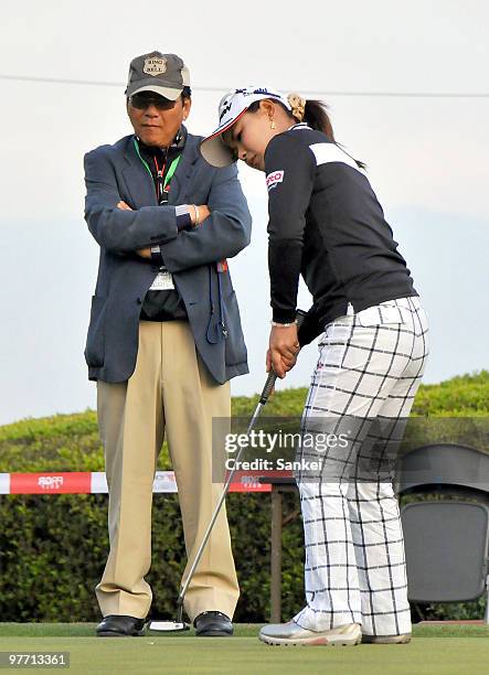 Sakura Yokomine practices putting while her father and lawmaker Yoshiro Yokomine looks during the round two of the Yokohama Tire Golf Tournament PRGR...