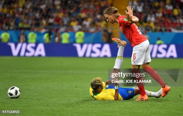 Switzerland's defender Michael Lang tackles Brazil's forward Neymar during the Russia 2018 World Cup Group E football match between Brazil and...