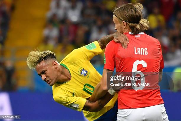 Switzerland's defender Michael Lang tackles Brazil's forward Neymar during the Russia 2018 World Cup Group E football match between Brazil and...