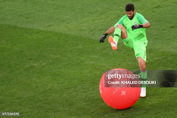 Brazil's goalkeeper Alisson bursts a balloon during the Russia 2018 World Cup Group E football match between Brazil and Switzerland at the Rostov...