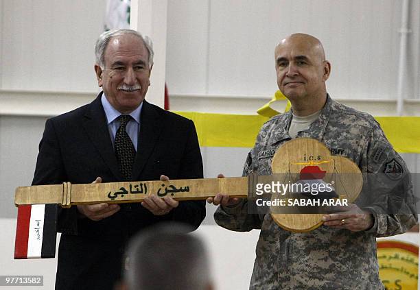 Brigadier General David Quantock hands Iraqi Minister of Justice Dara Nur al-Din a symbolic wooden key to Taji prison, a 107-million-dollar compound...