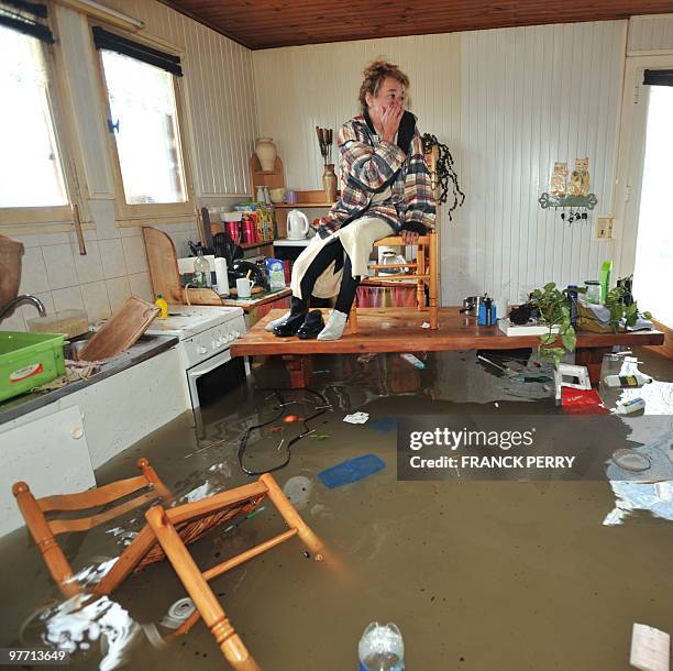 Awoman waits for rescuers in her kitchen on February 28 as a result of heavy floods, in La Faute-sur-Mer western France.Dubbed "Xynthia", the...