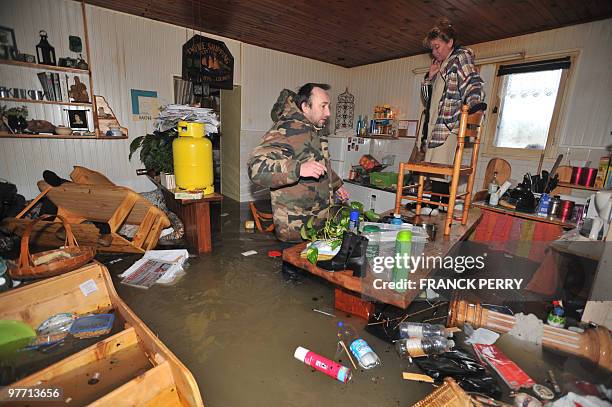 Two persons wait for rescuers in their kitchen on February 28 as a result of heavy floods, in La Faute-sur-Mer western France. Dubbed "Xynthia", the...