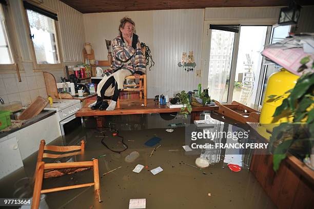 Woman waits fors rescuers in her kitchen on February 28 as a result of heavy floods, in La Faute-sur-Mer western France. Dubbed "Xynthia", the...