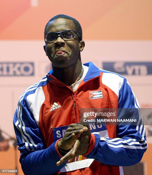 Cuban Dayron Robles gestures before receiving his gold medal he won in the Men's long jump at the 13th IAAF World Indoor Athletics Championships in...