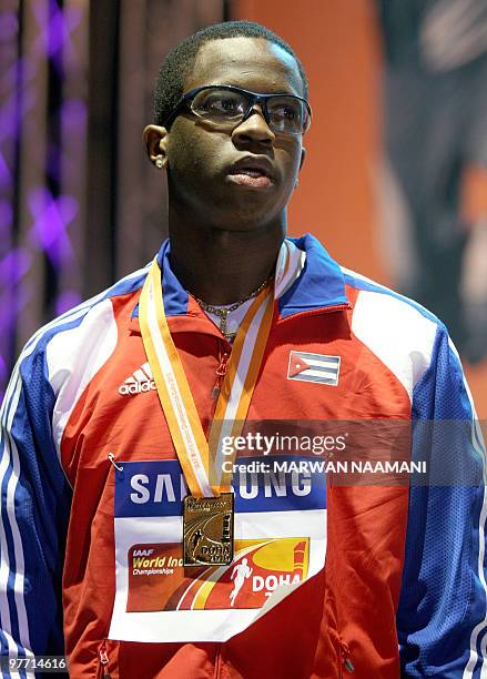 Cuban Dayron Robles poses with his gold medal that he won in the Men's long jump at the 13th IAAF World Indoor Athletics Championships in Doha on...