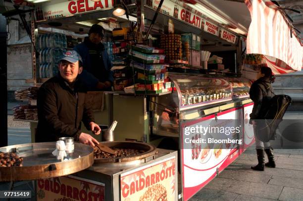 Vendor sells roasted chestnuts on the street in Milan, Italy, on Saturday, March 13, 2010. Italy's economy shrank more than originally estimated in...