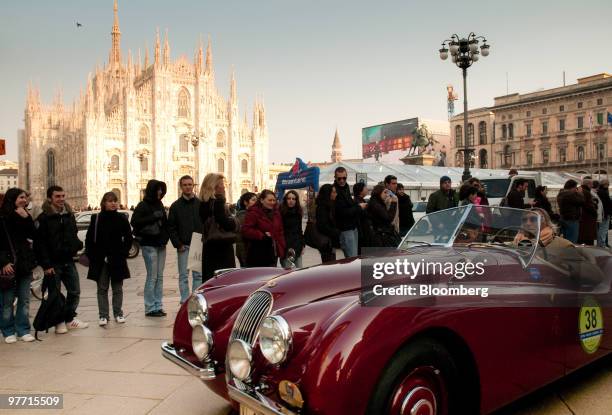 Vintage Jaguar automobile passes the Duomo Cathedral in Milan, Italy, on Saturday, March 13, 2010. Italy's economy shrank more than originally...