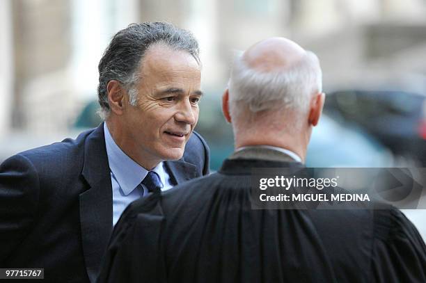 Former president of French football club Paris Saint Germain Laurent Perpere speaks with his lawyer Pierre Cornut-Gentille as they arrive on March...