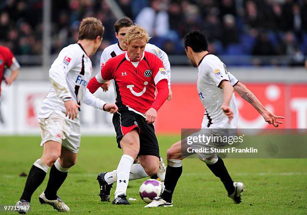 Mike Hanke of Hannover is challenged by players of Frankfurt during the Bundesliga match between Hannover 96 and Eintracht Frankfurt at AWD-Arena on...