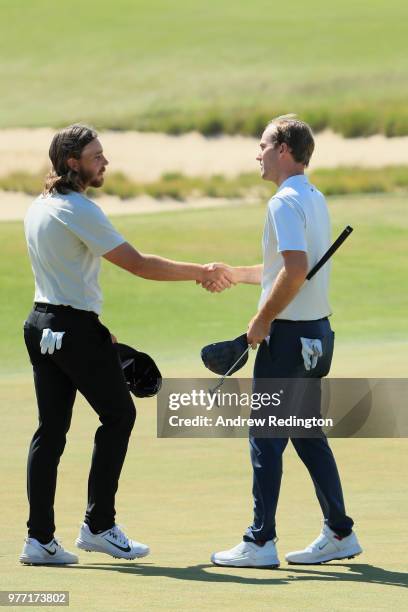 Tommy Fleetwood of England shakes hands with Russell Henley of the United States on the 18th green during the final round of the 2018 U.S. Open at...