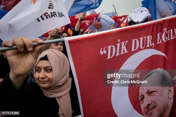 Woman holds a flag while listening to Turkey's President Recep Tayyip Erdogan speak during a AK Parti election rally on June 17, 2018 in Istanbul,...