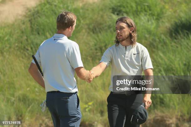 Russell Henley of the United States shakes hands with Tommy Fleetwood of England on the 18th green during the final round of the 2018 U.S. Open at...