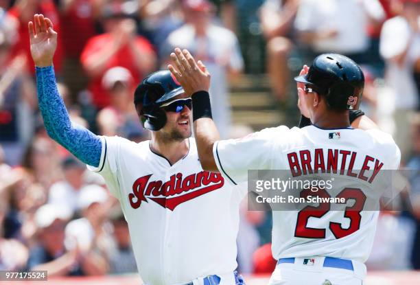 Lonnie Chisenhall and Michael Brantley of the Cleveland Indians celebrate after scoring on a double by Yan Gomes against the Minnesota Twins during...