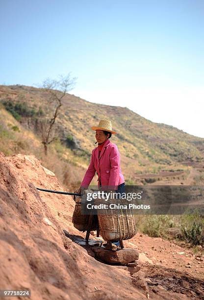 Woman gets water at a drinking water supply point, where she has waited for her turn for two days on March 15, 2010 in Huili County of Liangshan Yi...