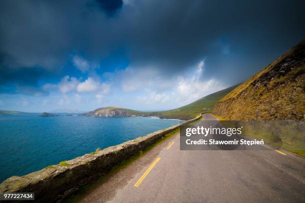 coastal road under moody sky, slea head, ireland - anillo de kerry fotografías e imágenes de stock