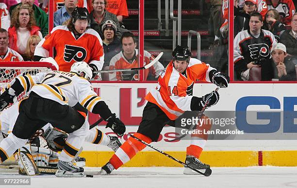 Ian Laperriere and Scott Hartnell of the Philadelphia Flyers set up a scoring opportunity against Steve Begin and goaltender Tuukka Rask of the...
