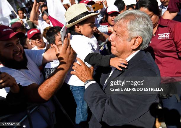 Mexican presidential candidate for the MORENA party, Andres Manuel Lopez Obrador, holds a kid during a campaign rally in Texcoco, state of Mexico, on...
