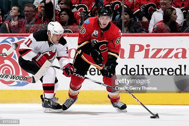 Mikael Backlund of the Calgary Flames skates against Dean McAmmond of the New Jersey Devils on March 5, 2010 at Pengrowth Saddledome in Calgary,...