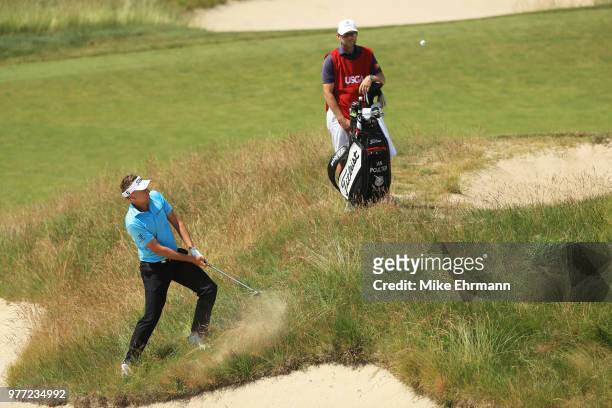 Ian Poulter of England plays a shot on the seventh hole as caddie James Walton looks on during the final round of the 2018 U.S. Open at Shinnecock...