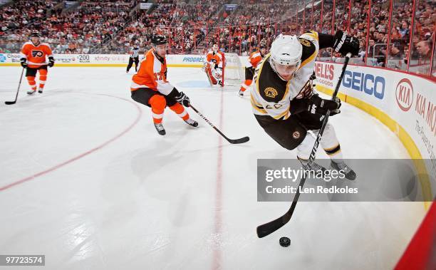 Blake Wheeler of the Boston Bruins skates the puck around Jeff Carter of the Philadelphia Flyers on March 11, 2010 at the Wachovia Center in...