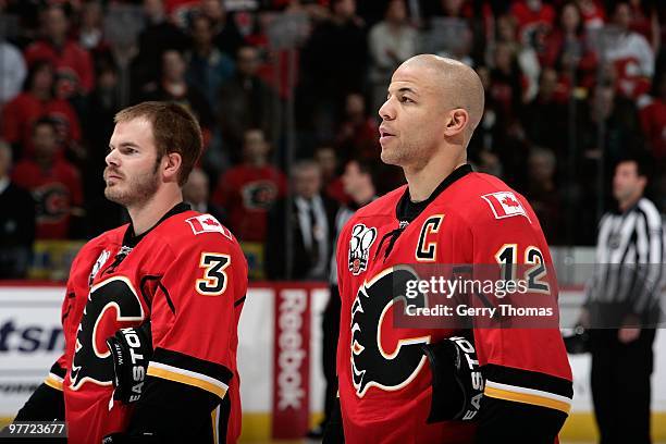 Jarome Iginla and Ian White of the Calgary Flames stands during the national anthem ceremony before the game against the New Jersey Devils on March...