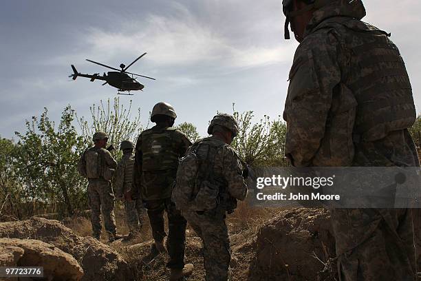 And Afghan Army soldiers maneuver on patrol with air support shortly before being attacked by Taliban insurgents on March 15, 2010 at Howz-e-Madad in...