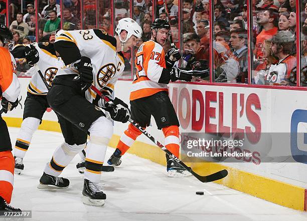 Zdeno Chara of the Boston Bruins handles the puck along the boards against Jeff Carter of the Philadelphia Flyers on March 11, 2010 at the Wachovia...