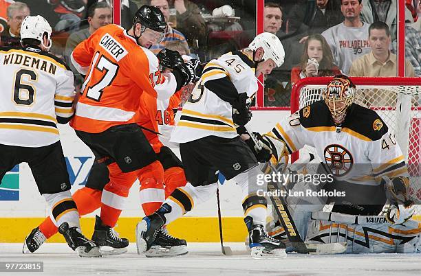 Jeff Carter and Danny Briere of the Philadelphia Flyers take a shot on goal against Dennis Wideman, Mark Stuart and Tuukka Rask of the Boston Bruins...