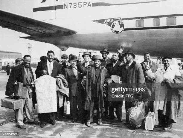 American jazz musician Count Basie and his orchestra arrive at London Airport for a tour of Britain, 4th April 1957. Basie is in the front centre,...