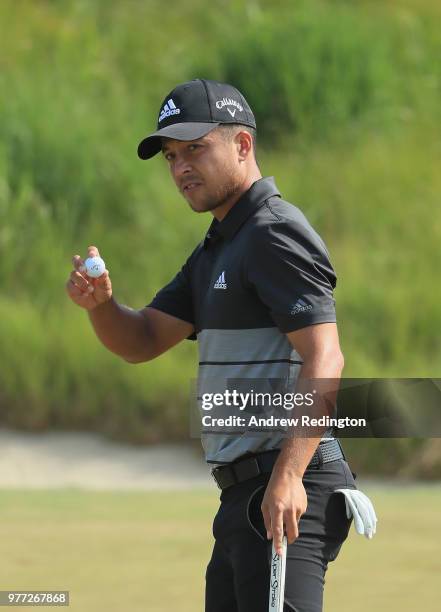 Xander Schauffele of the United States waves after putting on the 18th green during the final round of the 2018 U.S. Open at Shinnecock Hills Golf...