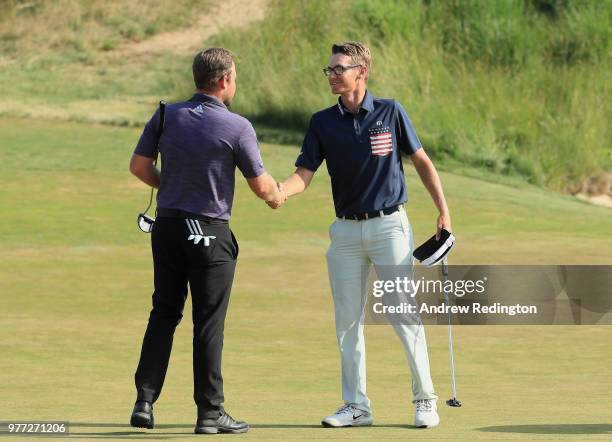 Tyrrell Hatton of England shakes hands with Dylan Meyer of the United States on the 18th green during the final round of the 2018 U.S. Open at...