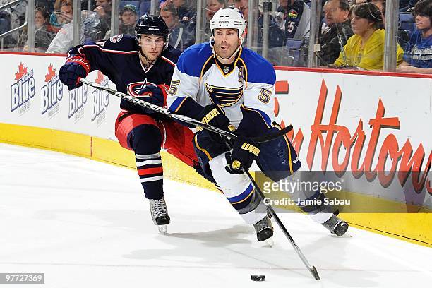 Defenseman Barret Jackman of the St. Louis Blues skates with the puck against forward Derick Brassard of the Columbus Blue Jackets on March 13, 2010...