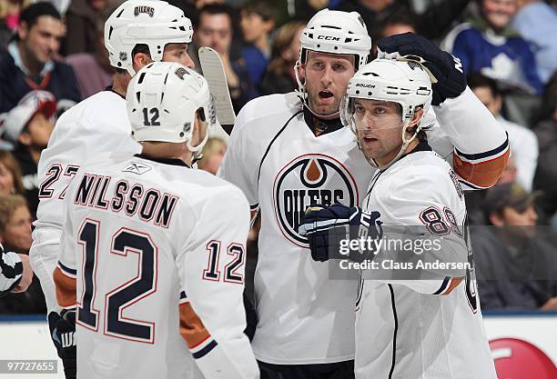 Sam Gagner, Robert Nilsson, and Ryan Whitney of the Edmonton Oilers celebrate teammate Dustin Penner's goal in a game against the Toronto Maple Leafs...