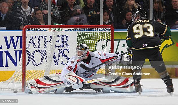 Philipp Grubauer of the Windsor Spitfires makes a big save against Justin Taylor of the London Knights in a game on March 12, 2010 at the John Labatt...