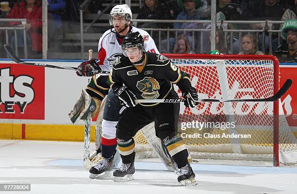 Zack Kassian of the Windsor Spitfires stands in behind Scott Harrington of the London Knights in a game on March 12, 2010 at the John Labatt Centre...